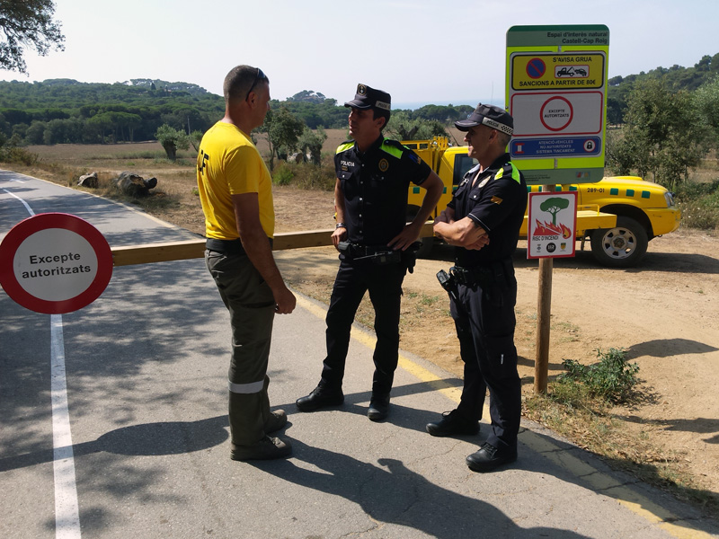 Agents de la Policia Local de Palamós i un membre de l'ADF Gavarres Marítima, davant la tanca d'accés al camí de la platja de Castell i de cala Estret