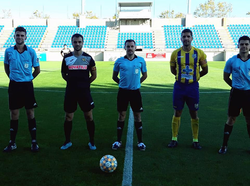 El capità David Cano, amb el seu homòleg del Tona i la tripleta arbitral, abans del partit de diumenge. (Foto: Palamós CF).