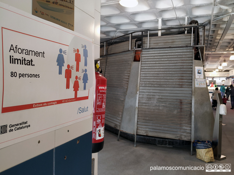 Cartell informatiu sobre l'aforament limitat en un dels accessos al Mercat Municipal.