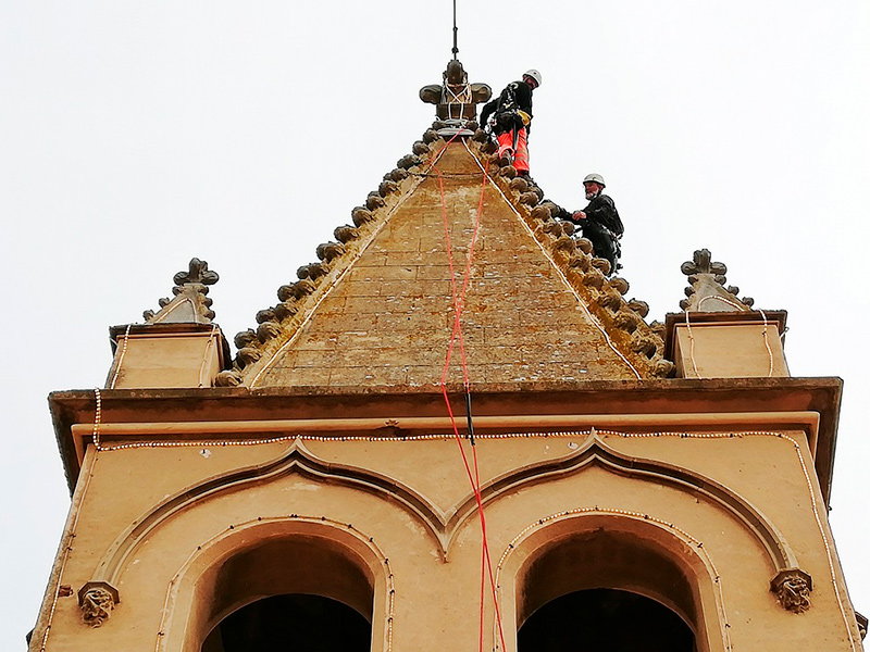 Operatis revisant la il·luminació nadalenca del campanar de l'església de Palamós. (Foto: Ajuntament de Palamós).
