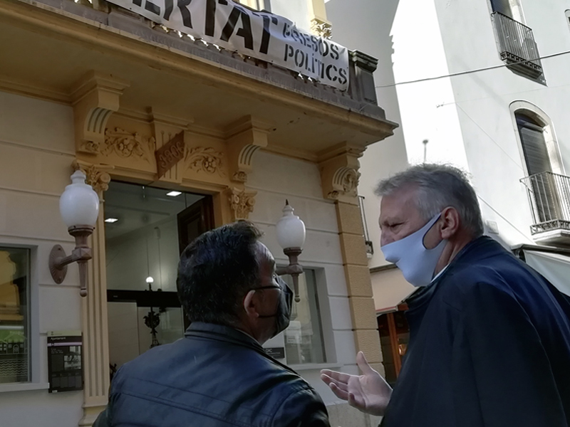 Cristóbal Posadas amb el cap de llista de C's per Girona, Jean Castel, sota la pancarta, que demana l'alliberament dels presos polítics.