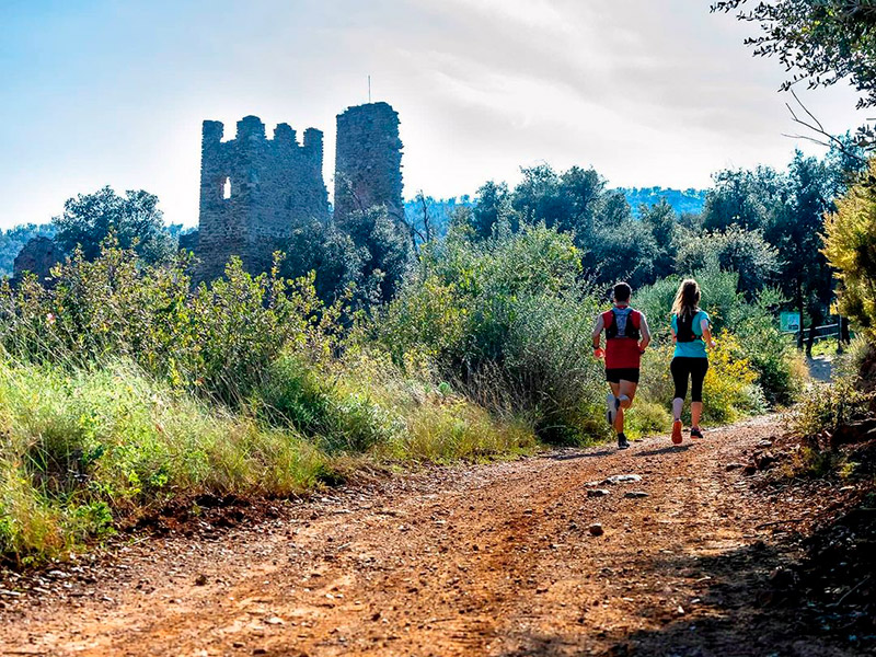 Dues persones fent esport a tocar del Castell de Vila-romà. (Foto: Deparament d'Esports de l'Ajuntament de Palamós).