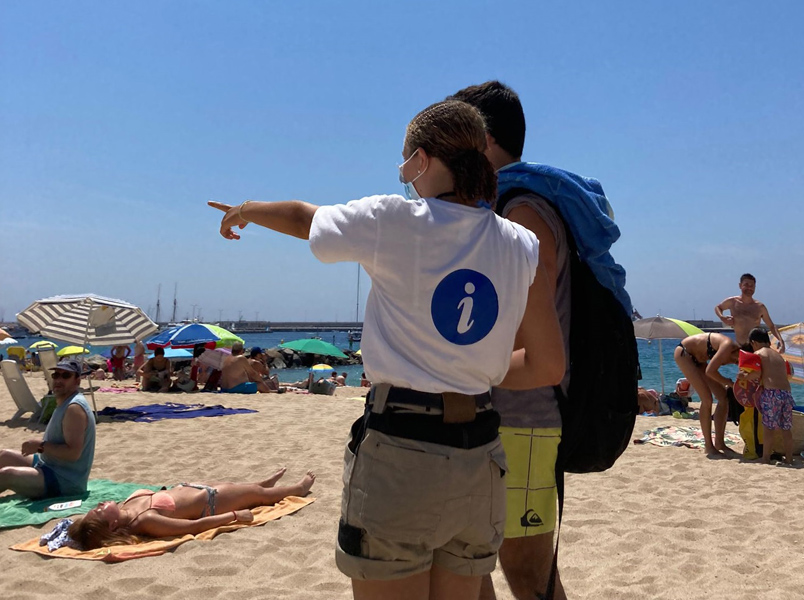 Una de les informadores realitzant la seva tasca a la platja Gran. (Foto: Ajuntament de Palamós).