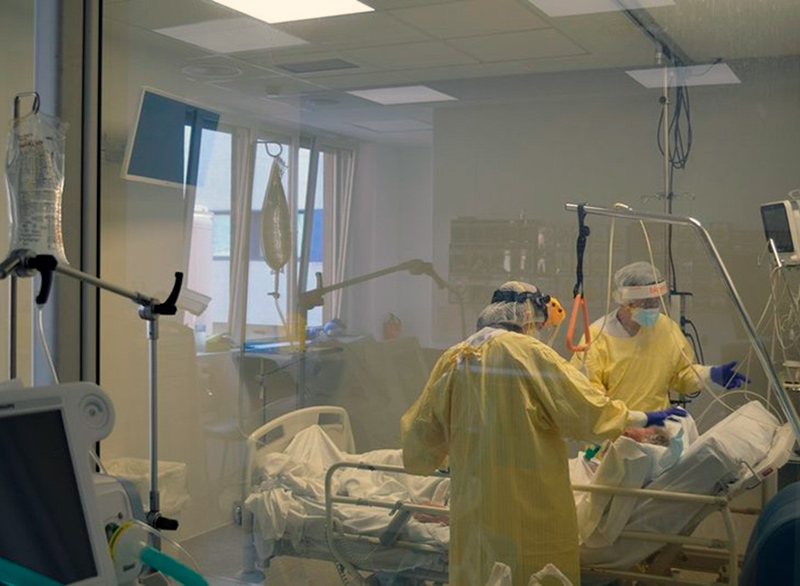 Dos sanitaris atenen a un pacient a la Unitat de Cures Intermèdies de l'hospital de Palamós. (Foto: SSIBE).