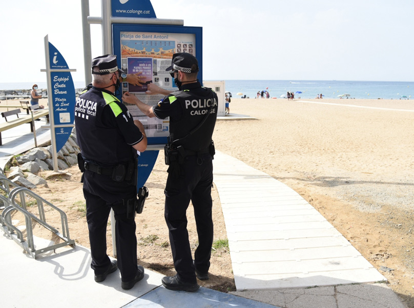 Agents Policia Local enganxant els cartells de senyalització de platges tancades a la nit. (Foto: Ajuntament de Calonge i Sant Antoni).