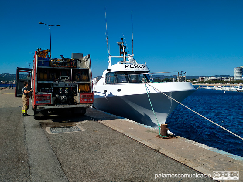 La barca amarrada a port, custodiada per una unitat dels Bombers de la Generalitat.