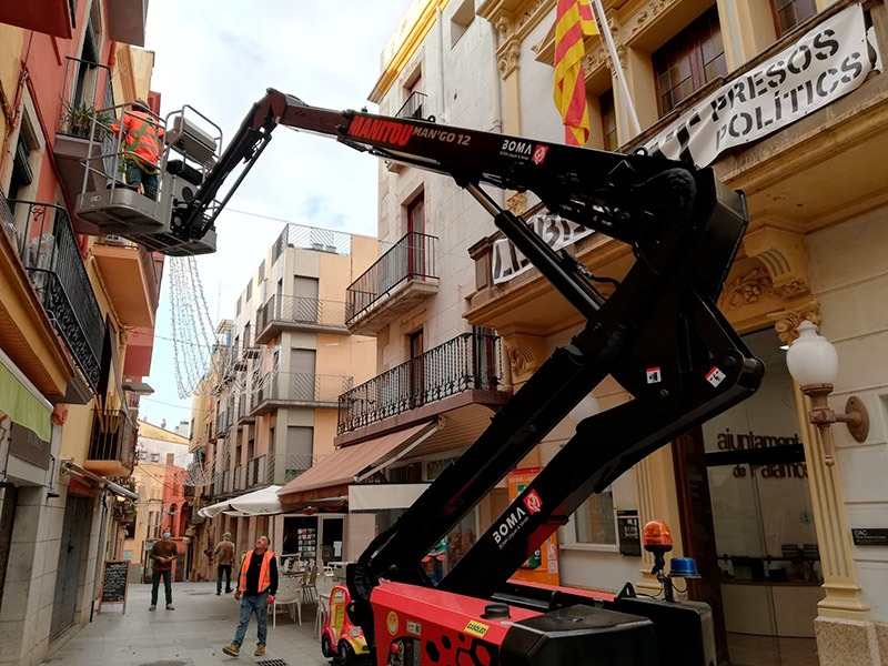 Operaris de la Brigada Municipal instal·lant llums de nadal al carrer Major de Palamós. (Foto: Ajuntament de Palamós).