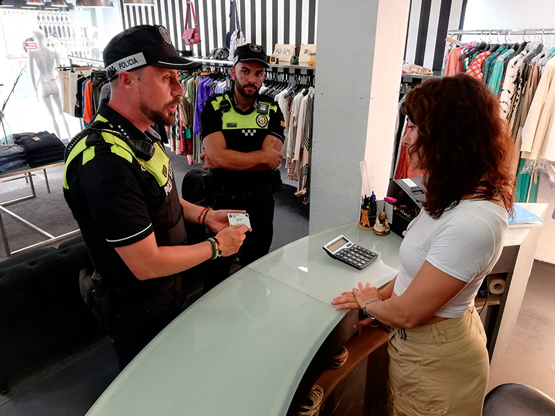 Agents de la Policia Local informen de la campanya en un comerç de Palamós. (Foto: Ajuntament de Palamós).