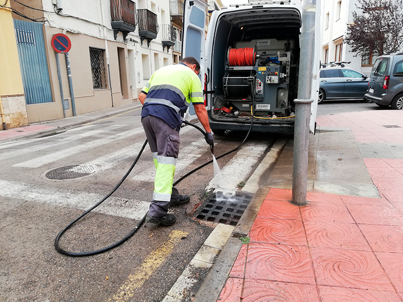 Un operari neteja un embornal al carrer del Carmel. (Foto: Ajuntament de Palamós).