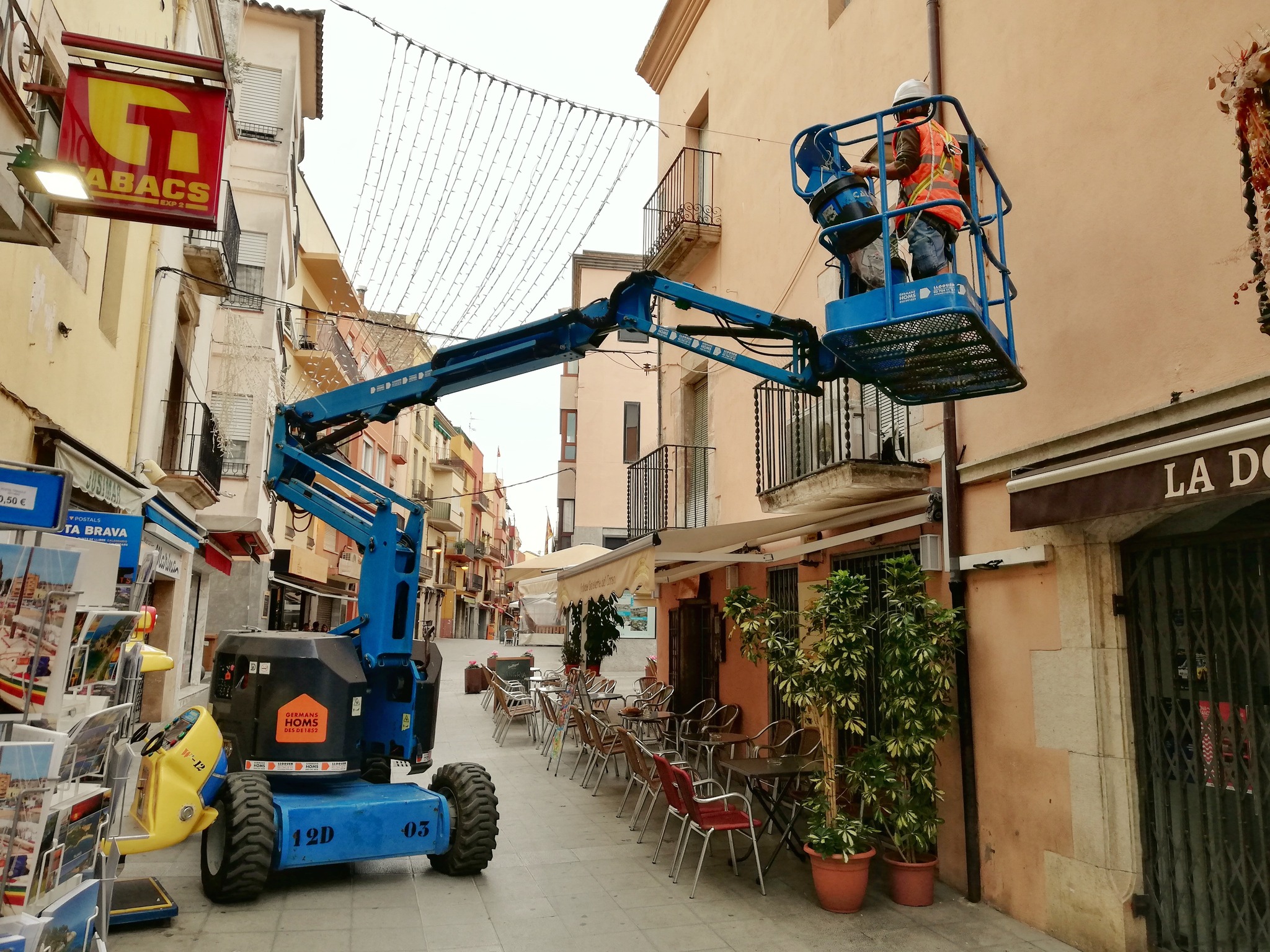 Operaris de la Brigada Municipal instal·lant els llums de Nadal al carrer Major. (Foto: Ajuntament de Palamós).