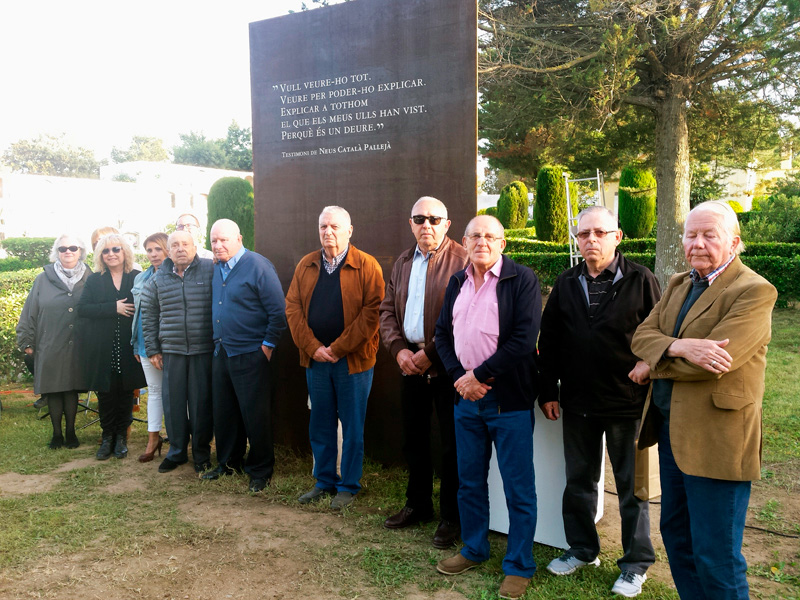 Imatge d'arxiu de familiars dels nou veïns del municipi que varen ser deportats, davant l'escultura dedicada a la seva memòria.