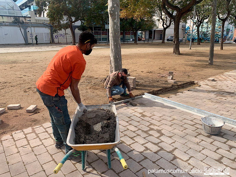 Imatge d'arxiu de dos operaris de la Brigada Municipal treballant a la Plaça del Suro.
