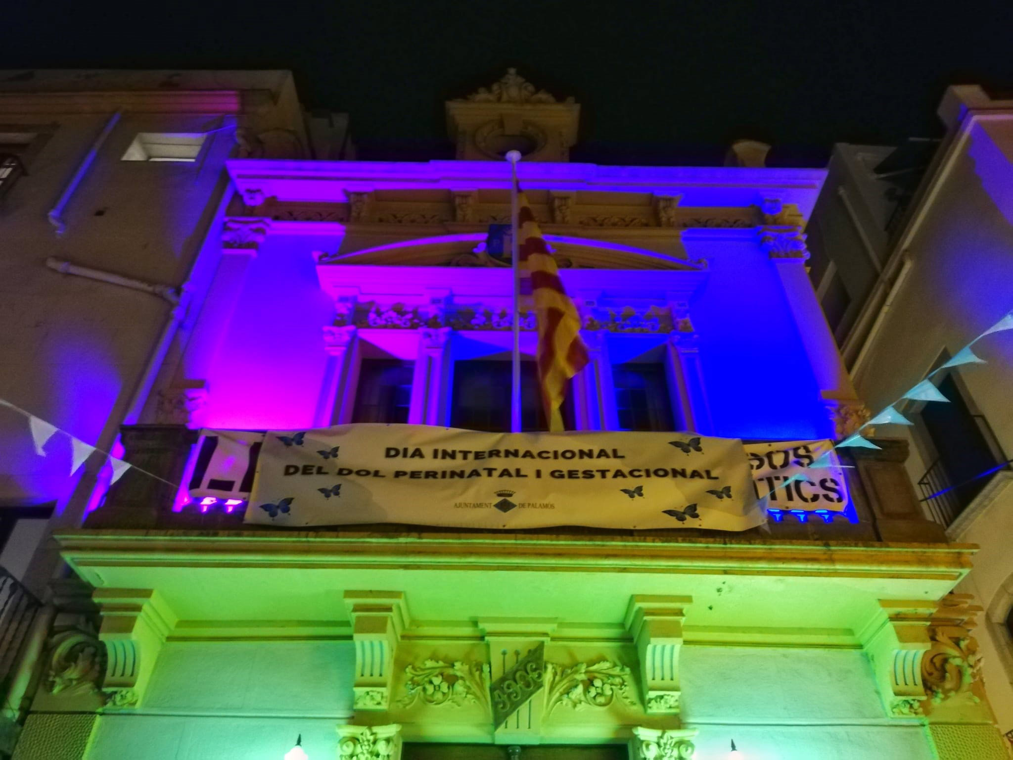 El balcó de l'Ajuntament il·luminat de rosa i blau. (Foto: Ajuntament de Palamós).
