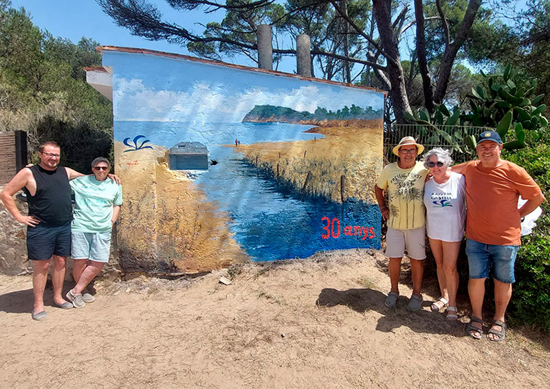 El pintor Martí Colls, amb samarreta groga, acompanyat per membres de Salvem Castell davant del mural commemoratiu. (Foto: Salvem Castell).