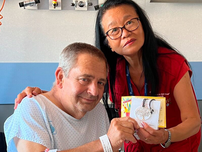 Un pacient ingressat a l'hospital, acompanyat d'una voluntària de SSIBE. (Foto: SSIBE).