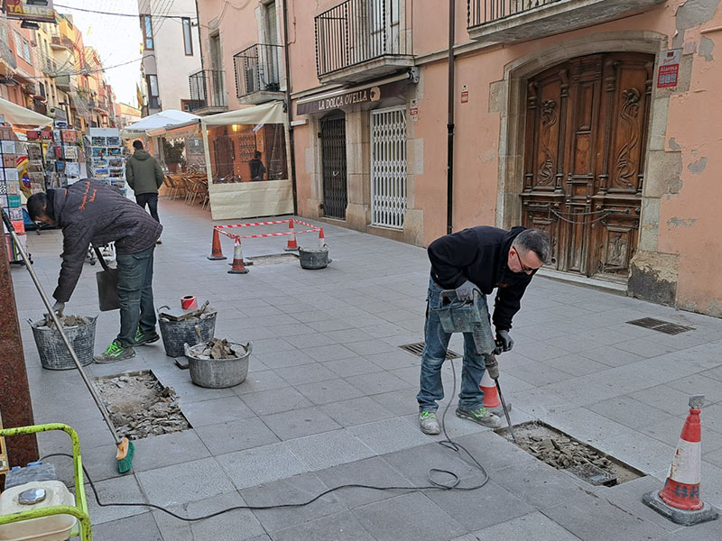 Operaris de la Brigada Municipal arranjant panots al carrer Major. (Foto: Ajuntament de Palamós).