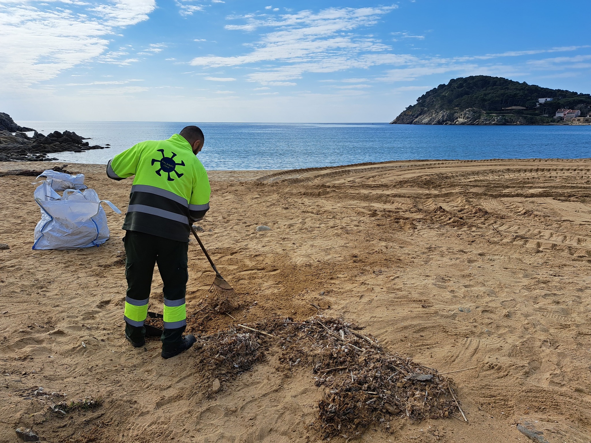 Un operari fent feines de neteja a la platja de la Fosca. (Foto: Ajuntament de Palamós).