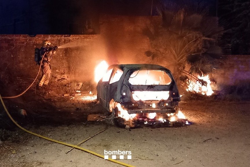 Els bombers actuant en l'extinció de l'incendi del cotxe, al carrer Riera. (Foto: Bombers de la Generalitat)