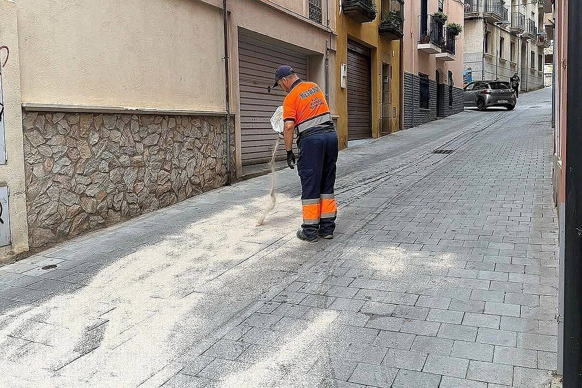 Un operari netejant amb sepiolita la fuita d'oli del vehicle avariat. (Foto: Ajuntament de Palamós).
